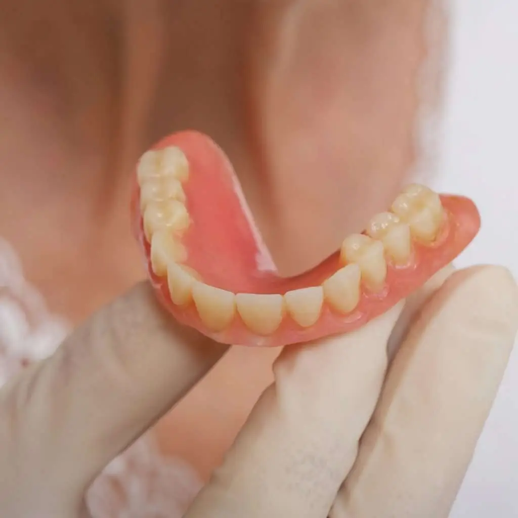 Denture in hand